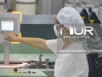 A worker is operating an intelligent production line at a textile company in Taizhou, Jiangsu Province, China, on March 12, 2024. (