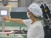 A worker is operating an intelligent production line at a textile company in Taizhou, Jiangsu Province, China, on March 12, 2024. (