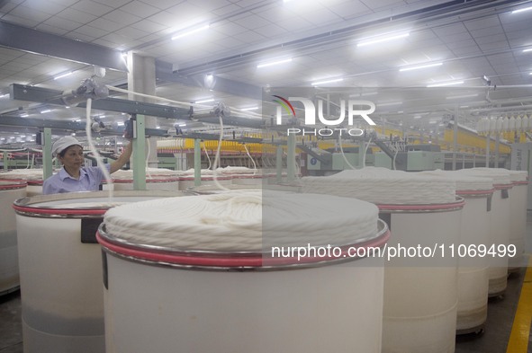 A worker is operating an intelligent production line at a textile company in Taizhou, Jiangsu Province, China, on March 12, 2024. 