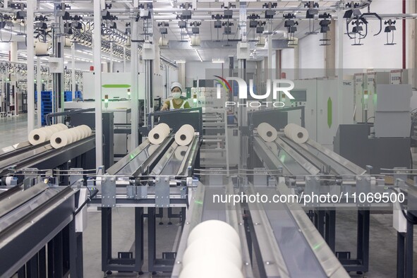 A worker is operating an intelligent production line at a textile company in Taizhou, Jiangsu Province, China, on March 12, 2024. 