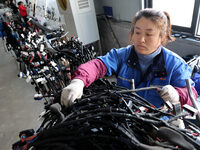 A worker is producing automotive wiring harness products at a workshop of an auto parts manufacturer in Binzhou, Shandong Province, China, o...