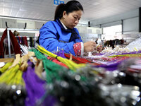 A worker is producing automotive wiring harness products at a workshop of an auto parts manufacturer in Binzhou, Shandong Province, China, o...