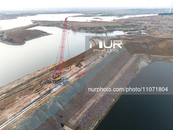 Construction workers and large machinery are working on the Heilongtan Reservoir reinforcement project in Lianyungang, China, on March 12, 2...