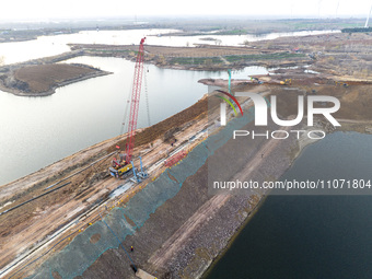 Construction workers and large machinery are working on the Heilongtan Reservoir reinforcement project in Lianyungang, China, on March 12, 2...