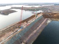 Construction workers and large machinery are working on the Heilongtan Reservoir reinforcement project in Lianyungang, China, on March 12, 2...