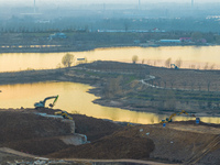 Construction workers and large machinery are working on the Heilongtan Reservoir reinforcement project in Lianyungang, China, on March 12, 2...