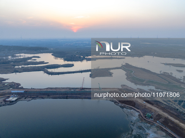 Construction workers and large machinery are working on the Heilongtan Reservoir reinforcement project in Lianyungang, China, on March 12, 2...