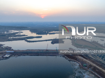 Construction workers and large machinery are working on the Heilongtan Reservoir reinforcement project in Lianyungang, China, on March 12, 2...