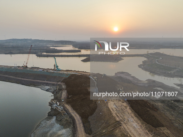 Construction workers and large machinery are working on the Heilongtan Reservoir reinforcement project in Lianyungang, China, on March 12, 2...