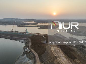 Construction workers and large machinery are working on the Heilongtan Reservoir reinforcement project in Lianyungang, China, on March 12, 2...