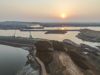 Construction workers and large machinery are working on the Heilongtan Reservoir reinforcement project in Lianyungang, China, on March 12, 2...