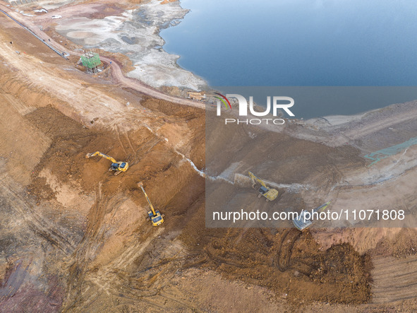 Construction workers and large machinery are working on the Heilongtan Reservoir reinforcement project in Lianyungang, China, on March 12, 2...