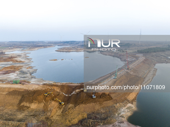 Construction workers and large machinery are working on the Heilongtan Reservoir reinforcement project in Lianyungang, China, on March 12, 2...