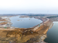 Construction workers and large machinery are working on the Heilongtan Reservoir reinforcement project in Lianyungang, China, on March 12, 2...