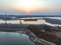 Construction workers and large machinery are working on the Heilongtan Reservoir reinforcement project in Lianyungang, China, on March 12, 2...