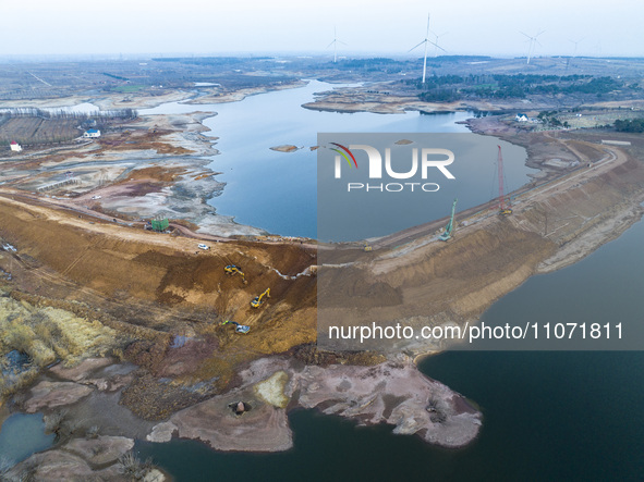 Construction workers and large machinery are working on the Heilongtan Reservoir reinforcement project in Lianyungang, China, on March 12, 2...