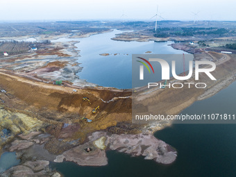 Construction workers and large machinery are working on the Heilongtan Reservoir reinforcement project in Lianyungang, China, on March 12, 2...