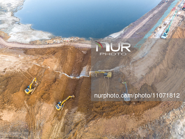 Construction workers and large machinery are working on the Heilongtan Reservoir reinforcement project in Lianyungang, China, on March 12, 2...