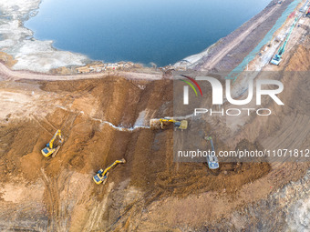 Construction workers and large machinery are working on the Heilongtan Reservoir reinforcement project in Lianyungang, China, on March 12, 2...