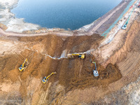 Construction workers and large machinery are working on the Heilongtan Reservoir reinforcement project in Lianyungang, China, on March 12, 2...