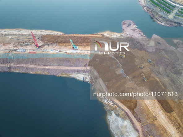 Construction workers and large machinery are working on the Heilongtan Reservoir reinforcement project in Lianyungang, China, on March 12, 2...