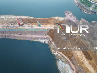 Construction workers and large machinery are working on the Heilongtan Reservoir reinforcement project in Lianyungang, China, on March 12, 2...