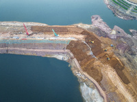 Construction workers and large machinery are working on the Heilongtan Reservoir reinforcement project in Lianyungang, China, on March 12, 2...