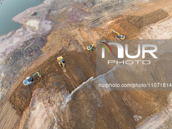 Construction workers and large machinery are working on the Heilongtan Reservoir reinforcement project in Lianyungang, China, on March 12, 2...