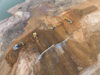 Construction workers and large machinery are working on the Heilongtan Reservoir reinforcement project in Lianyungang, China, on March 12, 2...