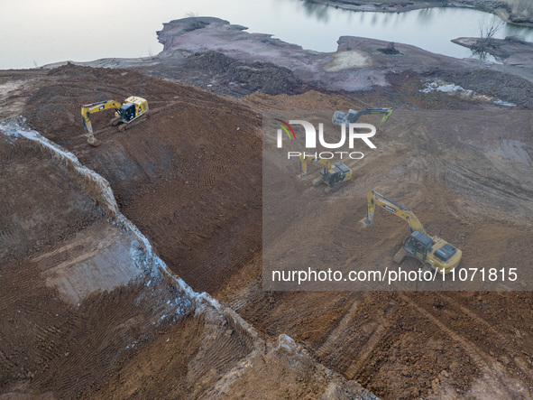 Construction workers and large machinery are working on the Heilongtan Reservoir reinforcement project in Lianyungang, China, on March 12, 2...