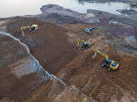 Construction workers and large machinery are working on the Heilongtan Reservoir reinforcement project in Lianyungang, China, on March 12, 2...