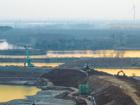 Construction workers and large machinery are working on the Heilongtan Reservoir reinforcement project in Lianyungang, China, on March 12, 2...