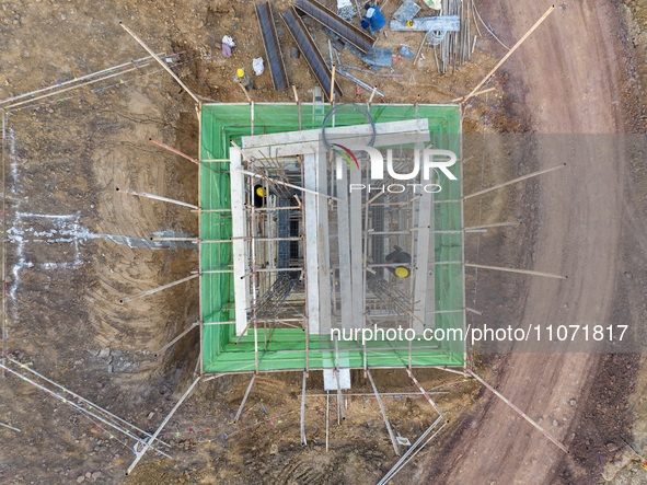 Construction workers and large machinery are working on the Heilongtan Reservoir reinforcement project in Lianyungang, China, on March 12, 2...