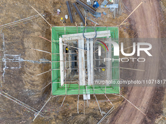 Construction workers and large machinery are working on the Heilongtan Reservoir reinforcement project in Lianyungang, China, on March 12, 2...