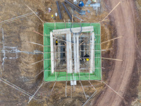 Construction workers and large machinery are working on the Heilongtan Reservoir reinforcement project in Lianyungang, China, on March 12, 2...