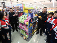 A staff member from the Trade branch of the Handan District Market Supervision Bureau is instructing primary school students on how to ident...