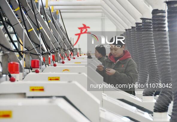 A worker is checking product quality in a digital intelligent production workshop at a hardware manufacturing company in Handan, North China...