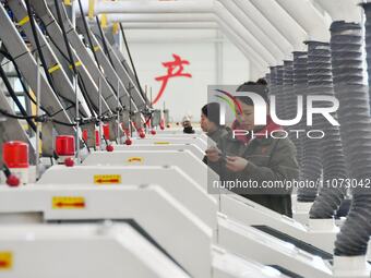 A worker is checking product quality in a digital intelligent production workshop at a hardware manufacturing company in Handan, North China...