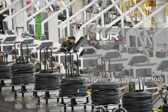 Workers are checking equipment operation at a digital intelligent production workshop at a hardware manufacturing company in Handan, North C...