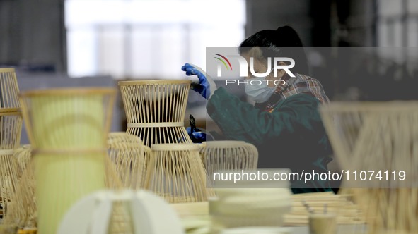 A worker is working on a production line in a craft company's workshop in Liuzhou, China, on March 10, 2024. 