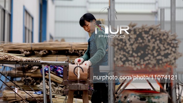 A worker is working on a production line in a craft company's workshop in Liuzhou, China, on March 10, 2024. 