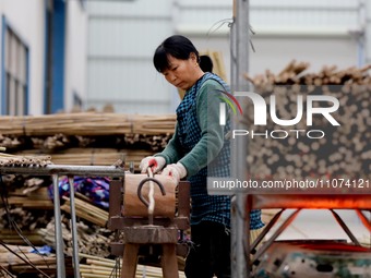 A worker is working on a production line in a craft company's workshop in Liuzhou, China, on March 10, 2024. (