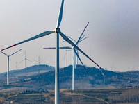 Giant windmills are spinning in the wind at Baoshan Town wind farm in the West Coast New Area of Qingdao, Shandong Province, China, on March...