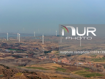 Giant windmills are spinning in the wind at Baoshan Town wind farm in the West Coast New Area of Qingdao, Shandong Province, China, on March...