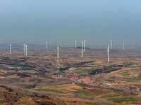 Giant windmills are spinning in the wind at Baoshan Town wind farm in the West Coast New Area of Qingdao, Shandong Province, China, on March...