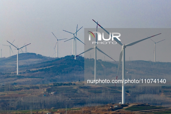 Giant windmills are spinning in the wind at Baoshan Town wind farm in the West Coast New Area of Qingdao, Shandong Province, China, on March...