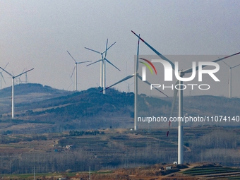 Giant windmills are spinning in the wind at Baoshan Town wind farm in the West Coast New Area of Qingdao, Shandong Province, China, on March...