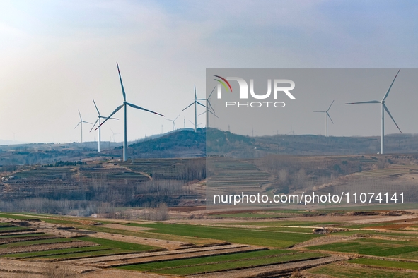 Giant windmills are spinning in the wind at Baoshan Town wind farm in the West Coast New Area of Qingdao, Shandong Province, China, on March...