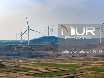 Giant windmills are spinning in the wind at Baoshan Town wind farm in the West Coast New Area of Qingdao, Shandong Province, China, on March...