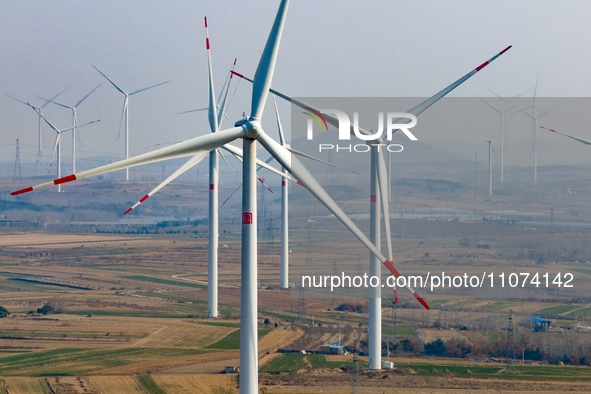 Giant windmills are spinning in the wind at Baoshan Town wind farm in the West Coast New Area of Qingdao, Shandong Province, China, on March...